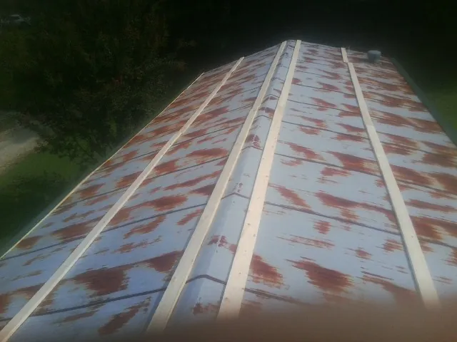 Rusted metal roof panels with new wood purlins before replacement — Storm Damage Roof Repair in Stites by Roofing Brothers