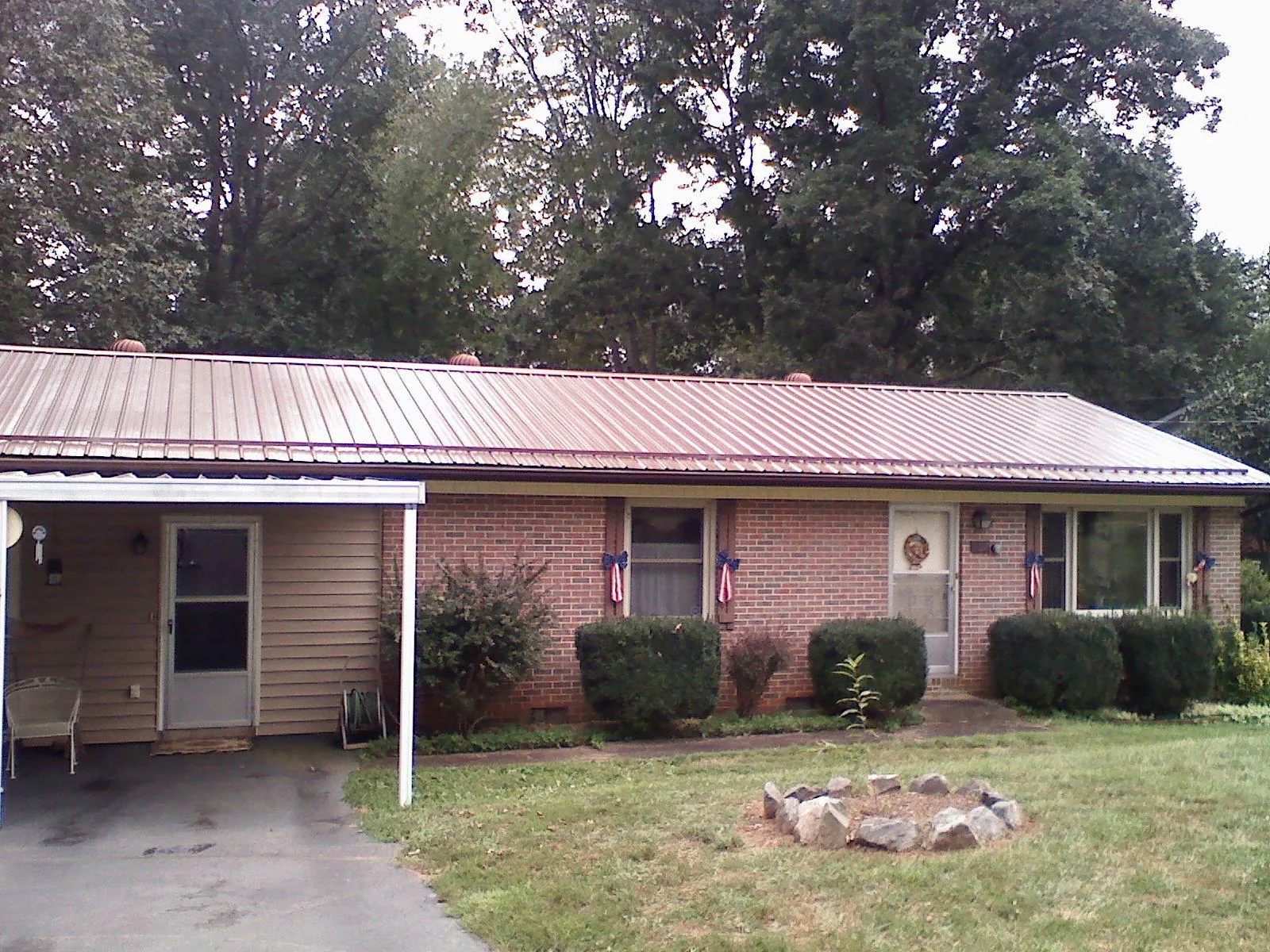 Bronze metal roof and carport on a brick ranch home — Roof Repair work by our crew in Stites