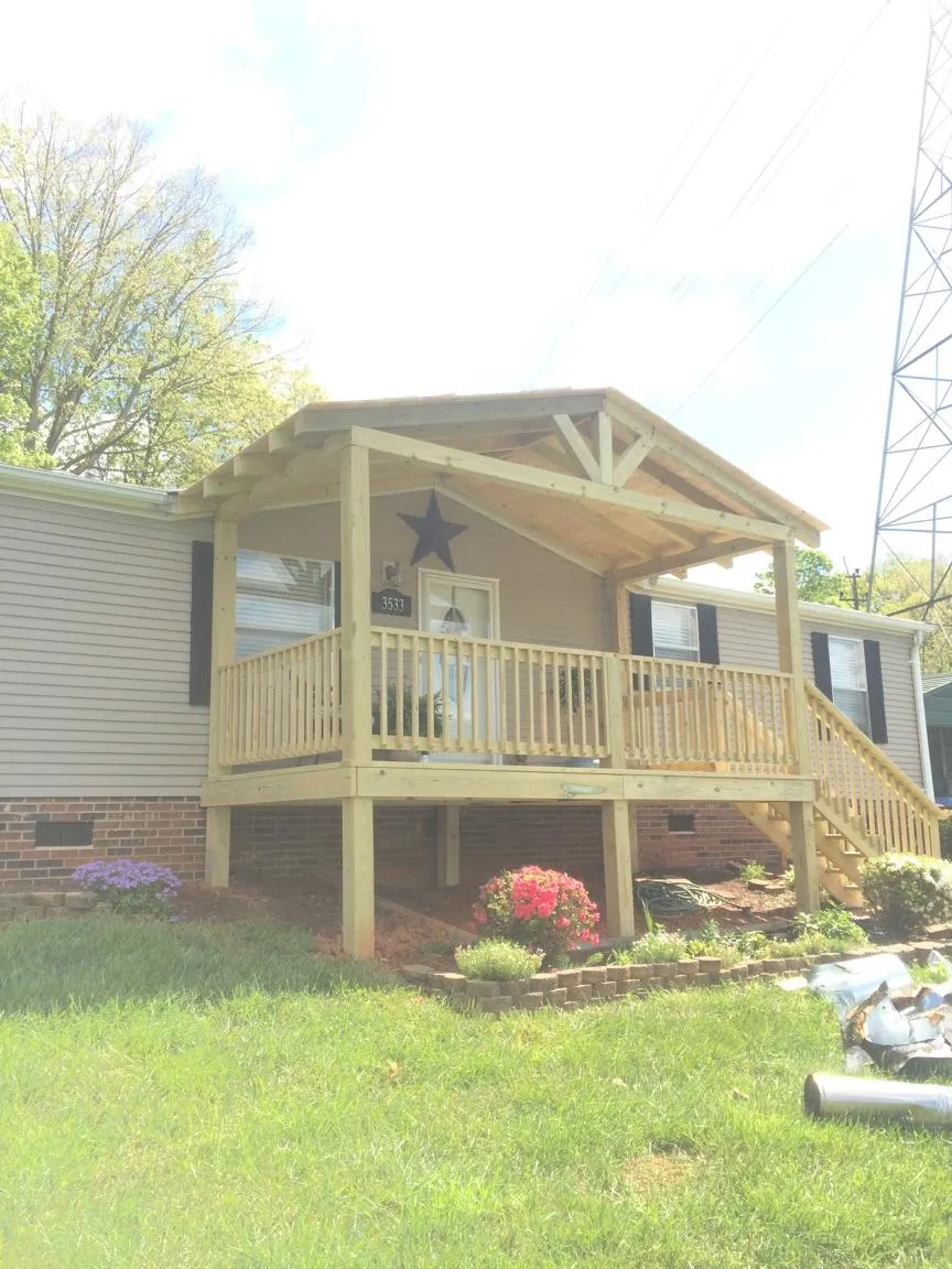 New gabled porch roof and deck railing added to a ranch home in Stites